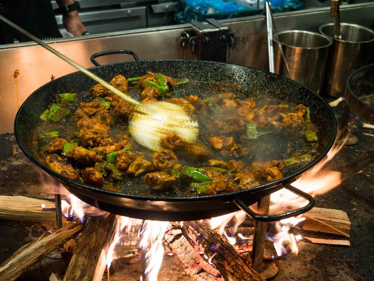 Mercado Little Spain餐厅正在烹制传统的瓦伦西亚海鲜饭:将兔肉、鸡肉和罗马豆一起硬煮至与番茄一起变成深棕色，然后加入高汤和米饭。gydF4y2Ba