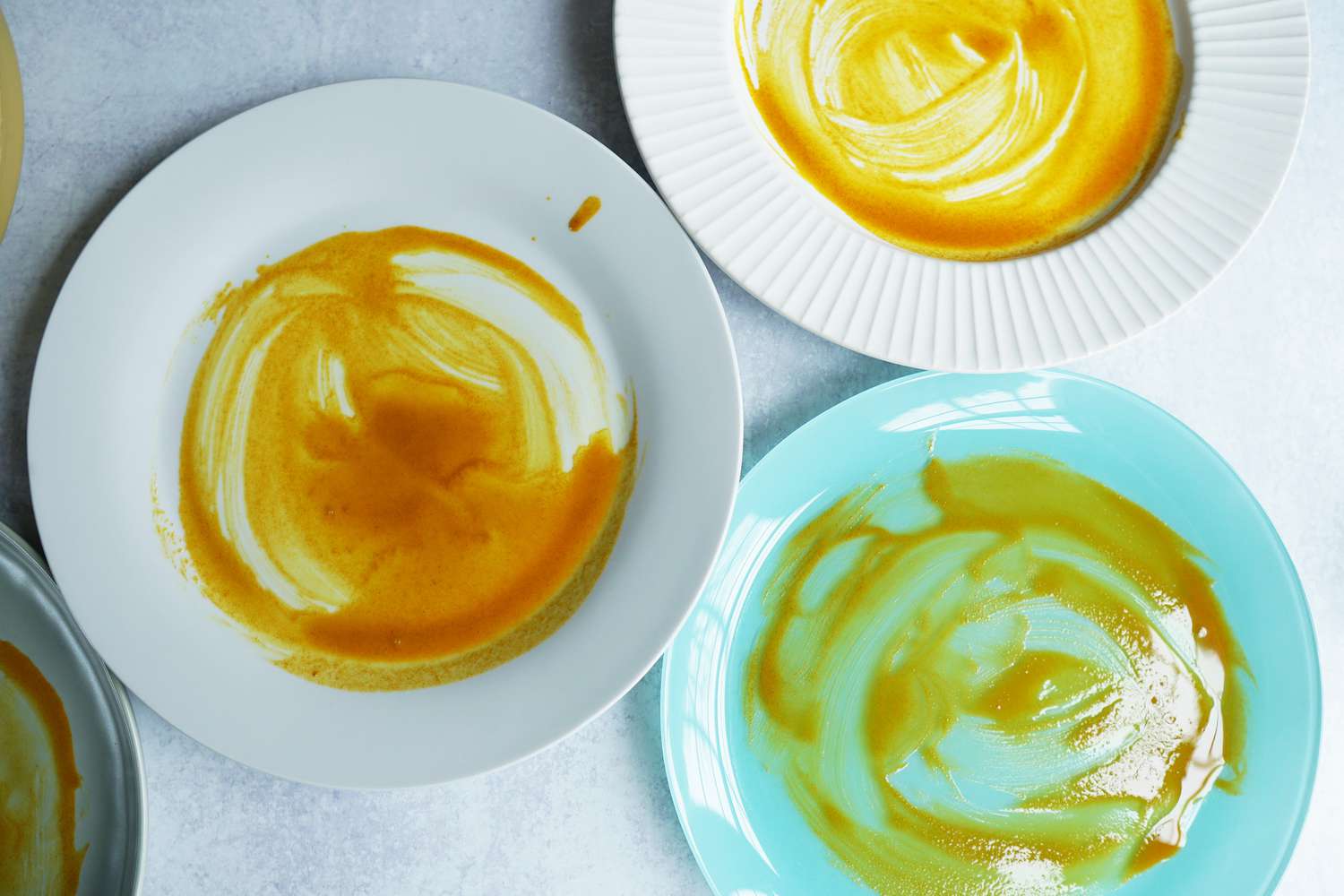 several dinner plates smeared with a turmeric-oil mixture