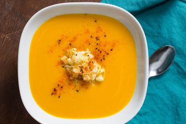 A bowl of creamy dairy-free squash soup garnished with chopped apples
