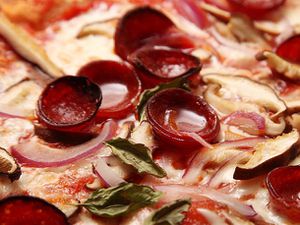 熟的,卷曲的意大利辣香肠与小池的脂肪表面上的披萨。
