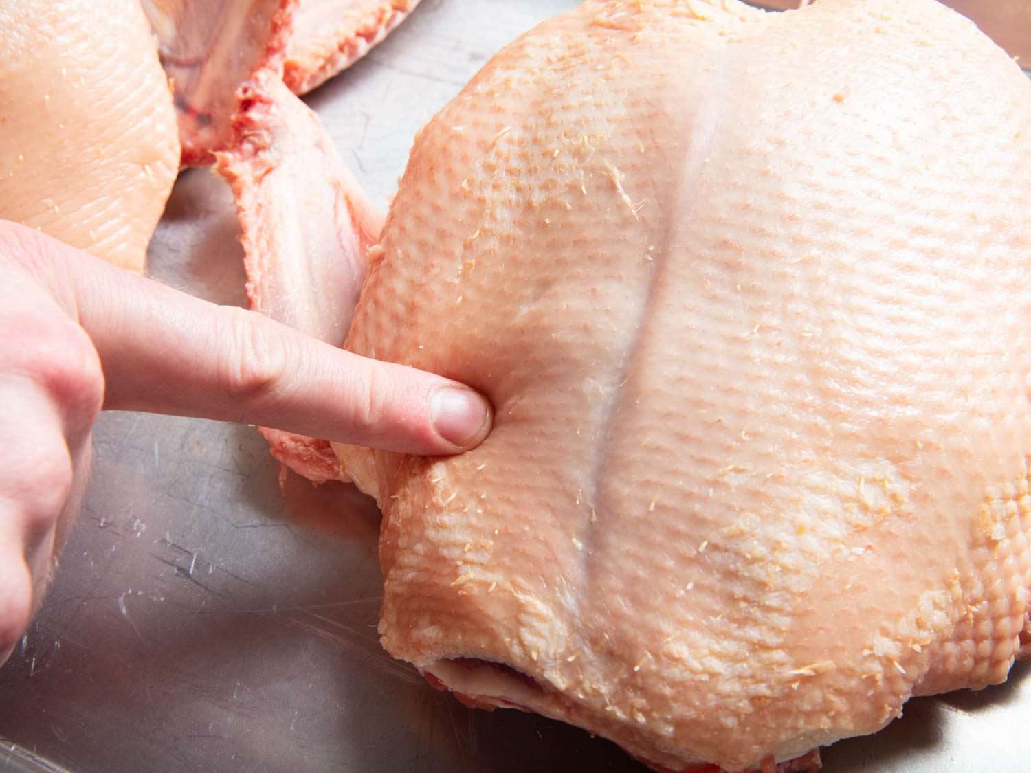 用手指按压鸭冠上的乳房，以显示第一天的肉有多软。