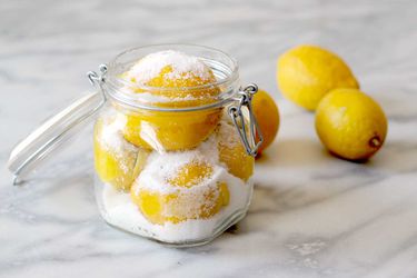 Lemons layered with salt for preserving in clamp-lid glass jar