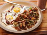 Plate with two sunny side-up eggs, a pile of home fries, and a fork