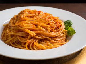 一碗浅白的意大利面，浇上新鲜的番茄酱。