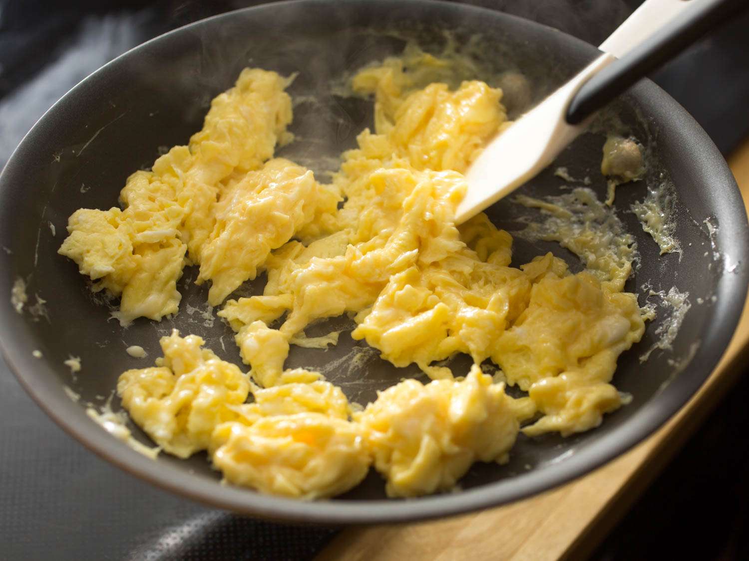 搅拌几乎完成的炒鸡蛋和大而蓬松的凝乳。