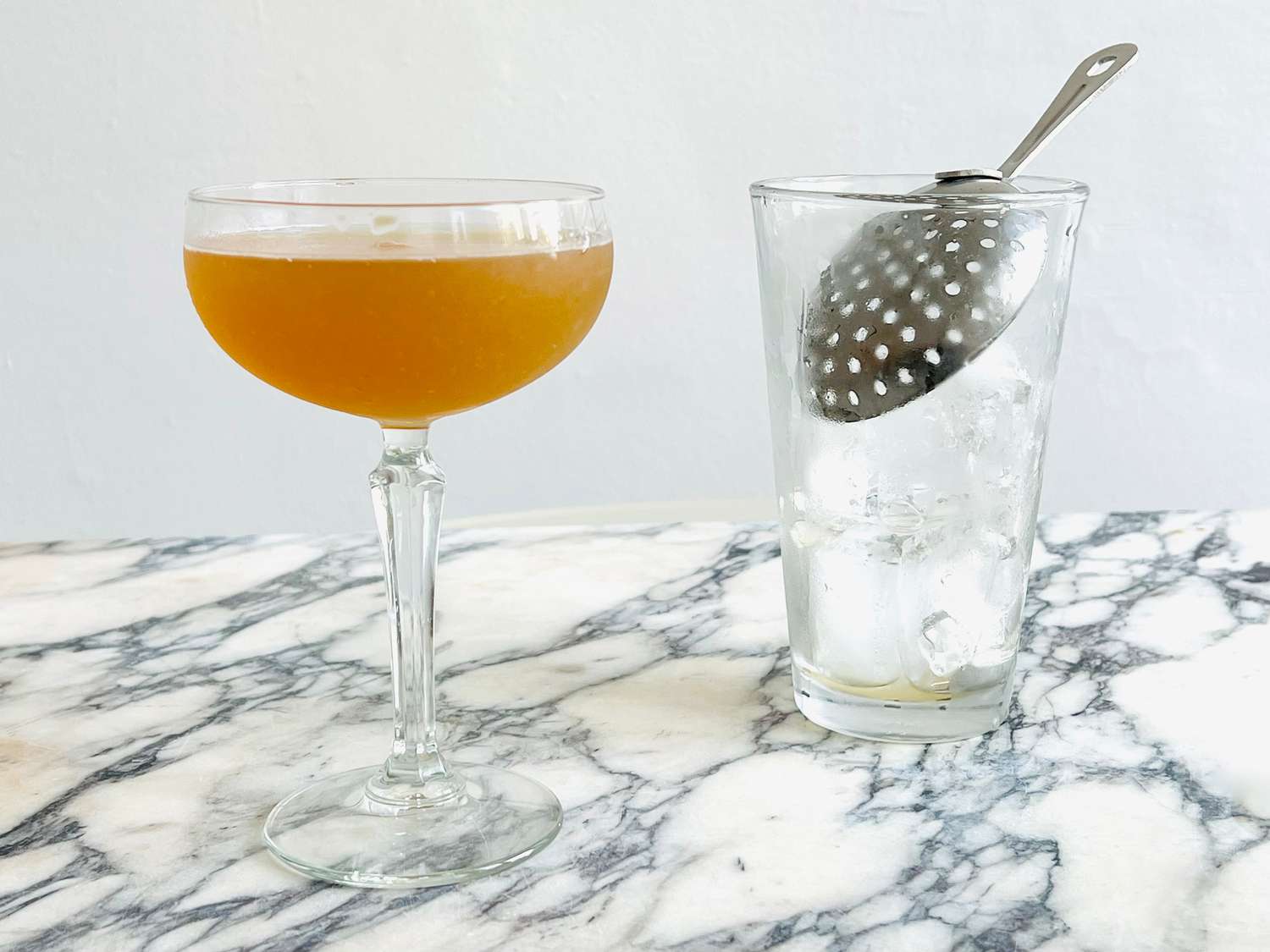 一个直柄朱勒普滤器，放在波士顿摇酒器底部，鸡尾酒放在一个双门式玻璃杯中。