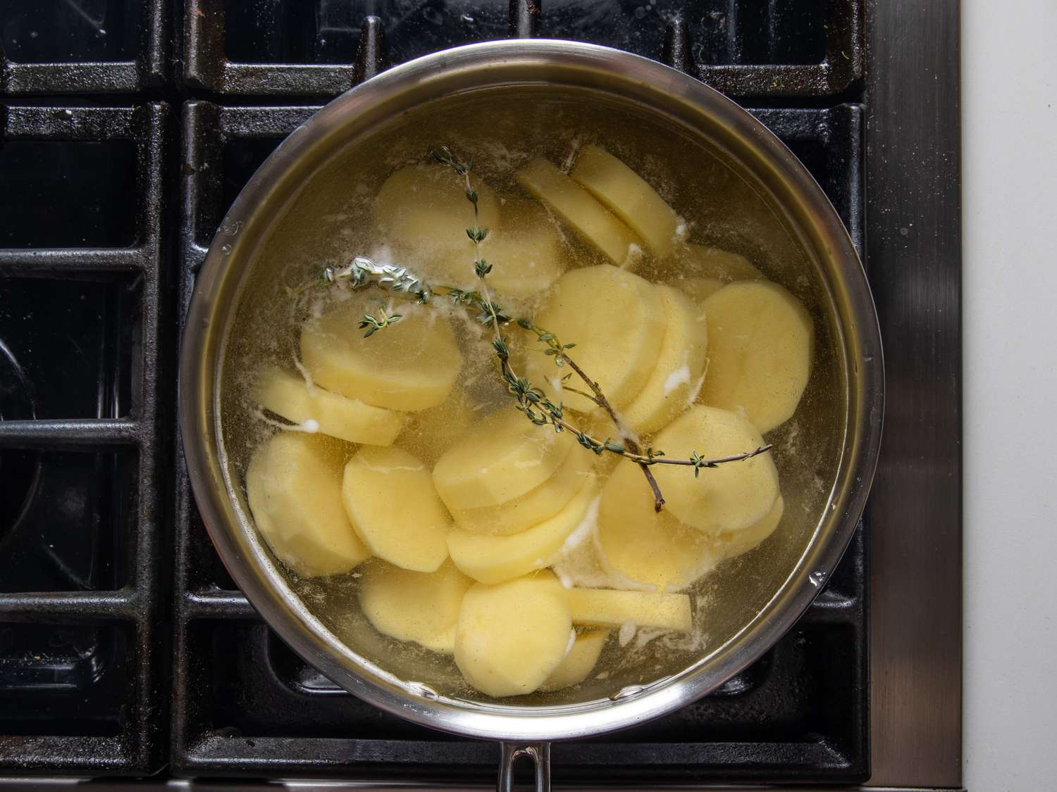 把育空黄金土豆切片放在一盆水中，再放上几根百里香小枝。