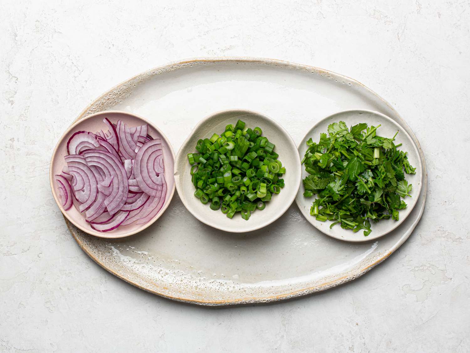 Onions, chives, and cilantro in small bowls