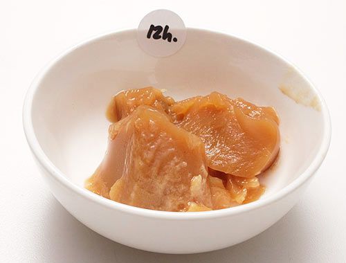 一小碗坚固的棕色猪肉汤，上面贴着写着12小时的贴纸。