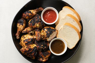 Pan chicken served with white bread and condiments.