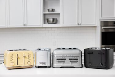 four toasters on a white countertop