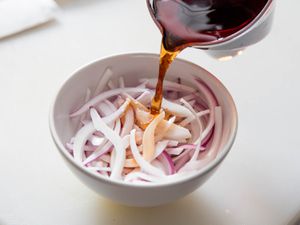 倒醋在红洋葱片容易在15分钟内快速腌洋葱。