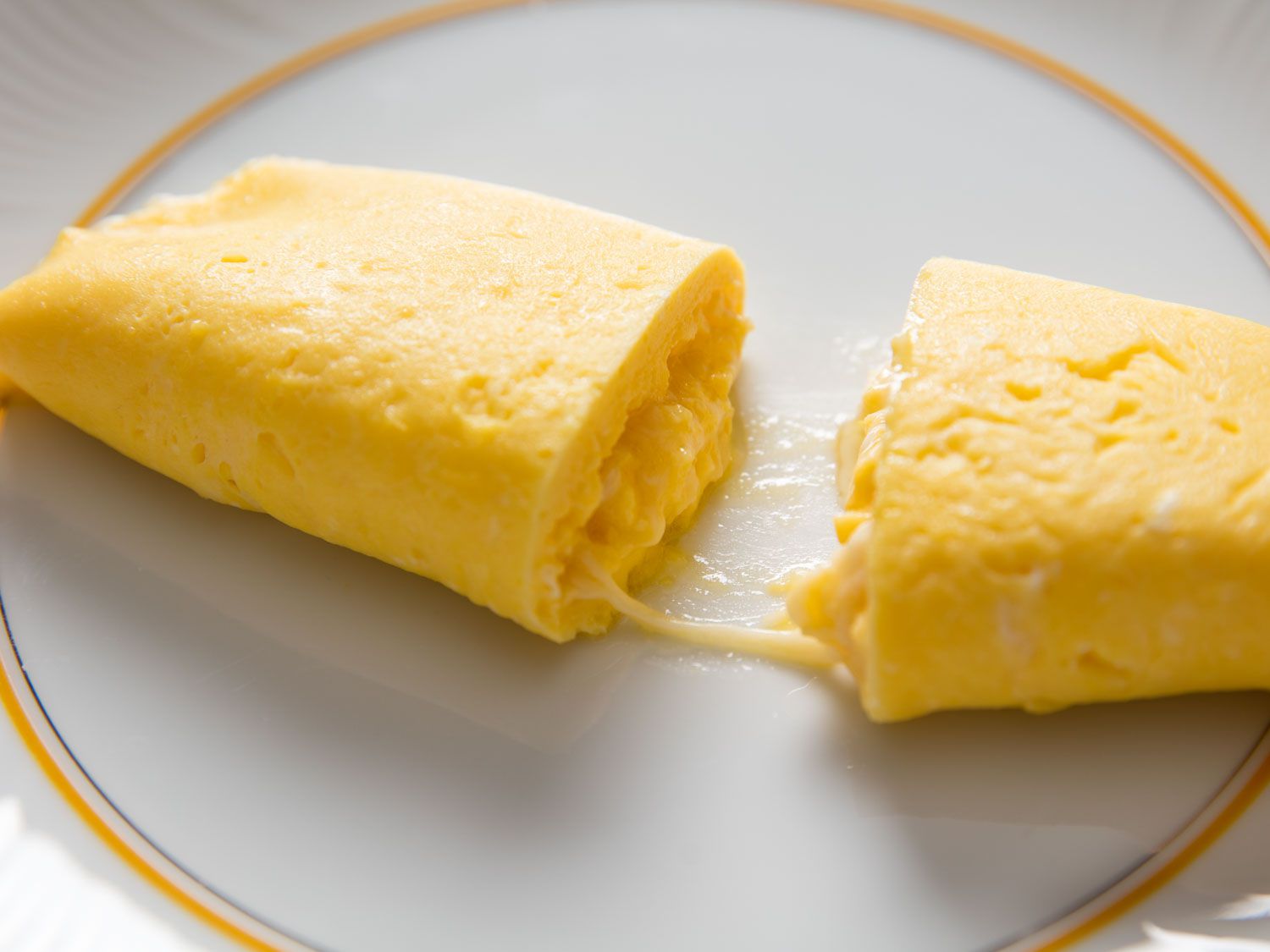 法式煎蛋卷中间有奶酪，切开放在白色盘子上。gydF4y2Ba