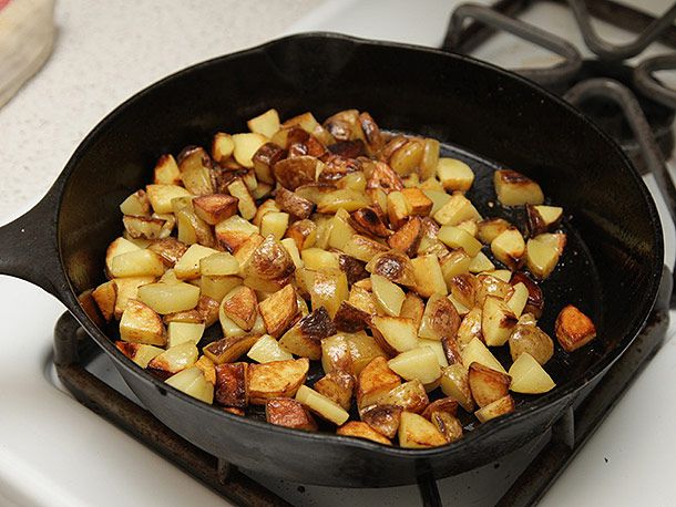 深褐色的土豆丁放在铸铁煎锅里。