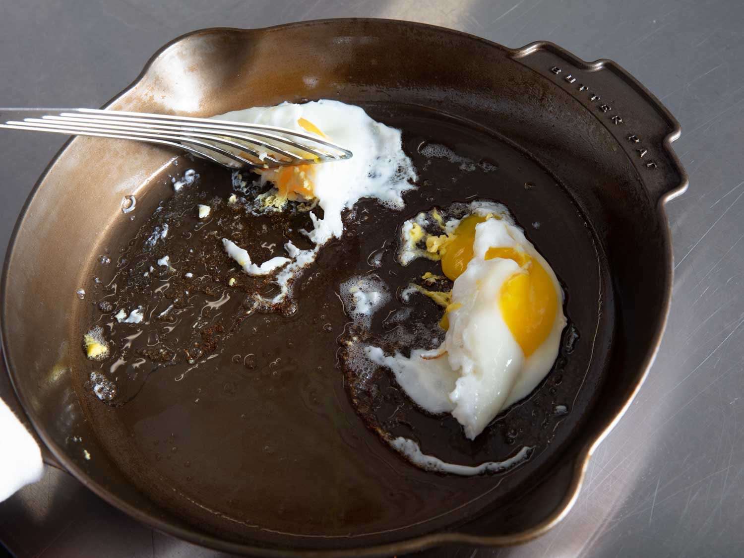 几乎每一个煎锅里都有鸡蛋卡住，比如图中所示的黄油煎锅里，当锅铲试图把鸡蛋提起来时，鸡蛋就会撕裂。