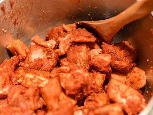 用木勺搅拌调味过的肉。