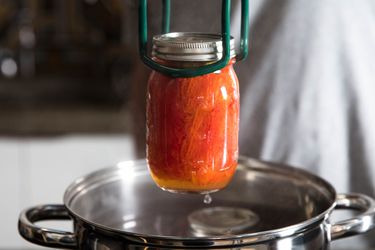 一罐加工番茄被删除从水浴用jar钳。