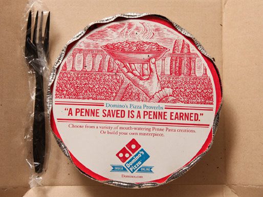 交付容器从Domino的圆铝盘与纸板顶部和铝边缘卷曲。一个塑料叉也在盒子里。