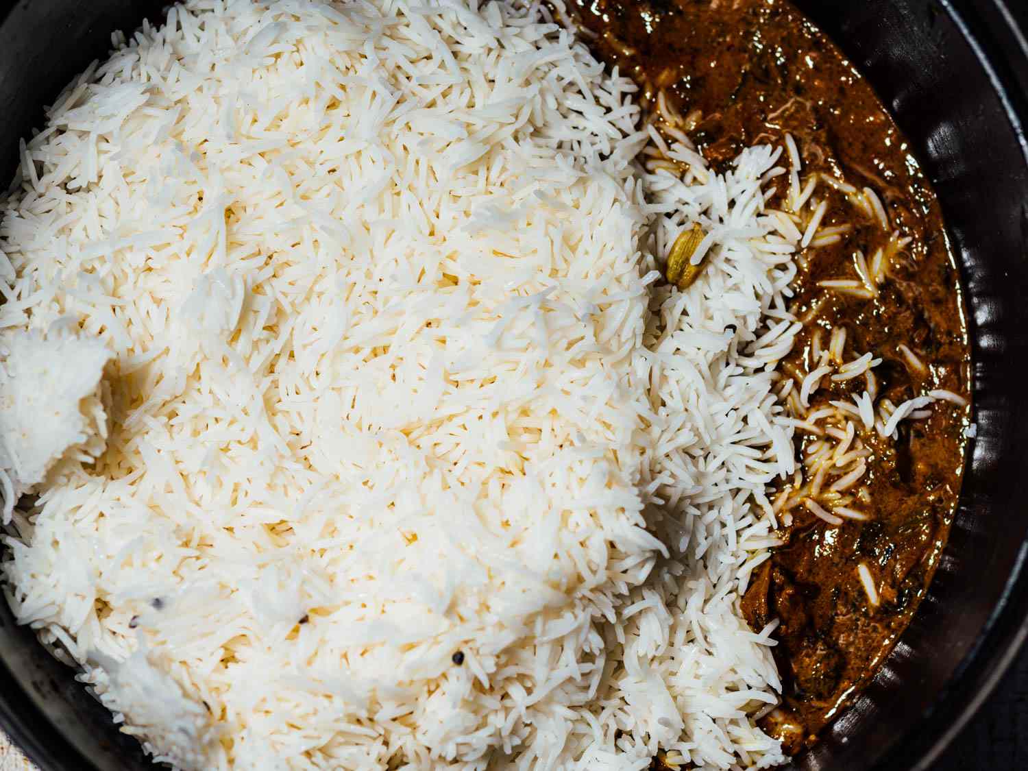 在荷兰烤箱中加入米饭，肉和腌料做印度香饭gydF4y2Ba