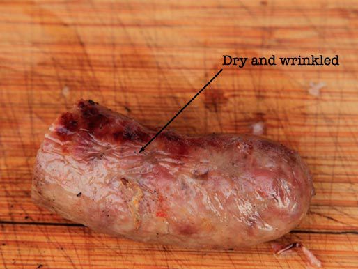 半根煮熟的香肠，上面的标签指出它干燥皱皱的外表