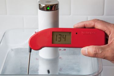 A Thermapen one taking the temperature of a sous vide water bath set to 134 degrees