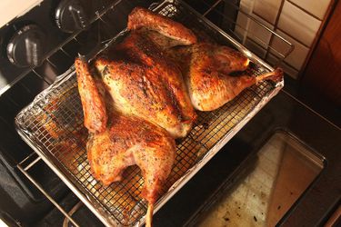 香草摩擦脆皮蝴蝶烤火鸡放在烤箱的架子上。