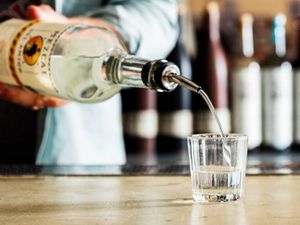 一杯mezcal从一个瓶子倒在一个酒吧。