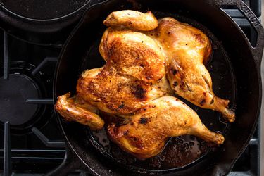 炉子上的铸铁煎锅里的整只鸡
