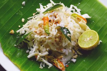 印度卷心菜沙拉配香蕉叶和半个酸橙。