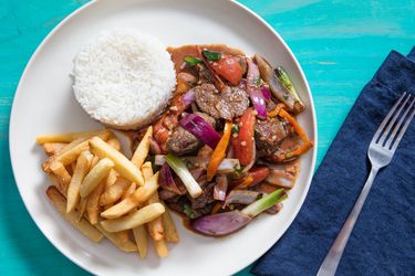 overhead view of lomo saltado plated with french fries and white rice