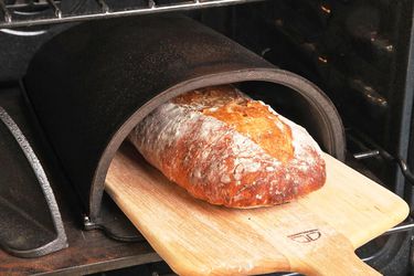 用木皮从福尔诺面包烤箱中取出一条面包。