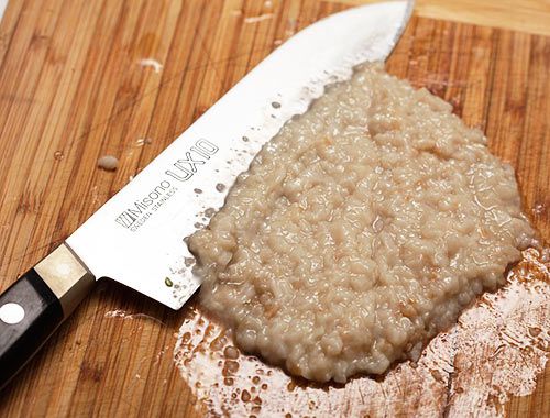 切成细丁的熟肥肉放在砧板上，旁边放着刀。