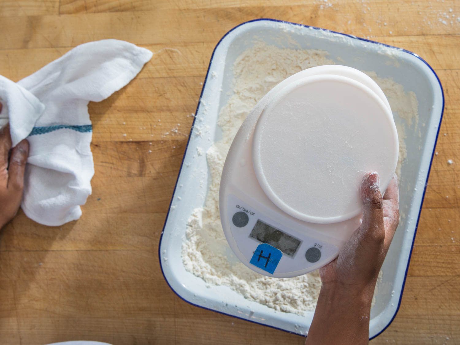 Removing digital kitchen scale from bowl of flour.
