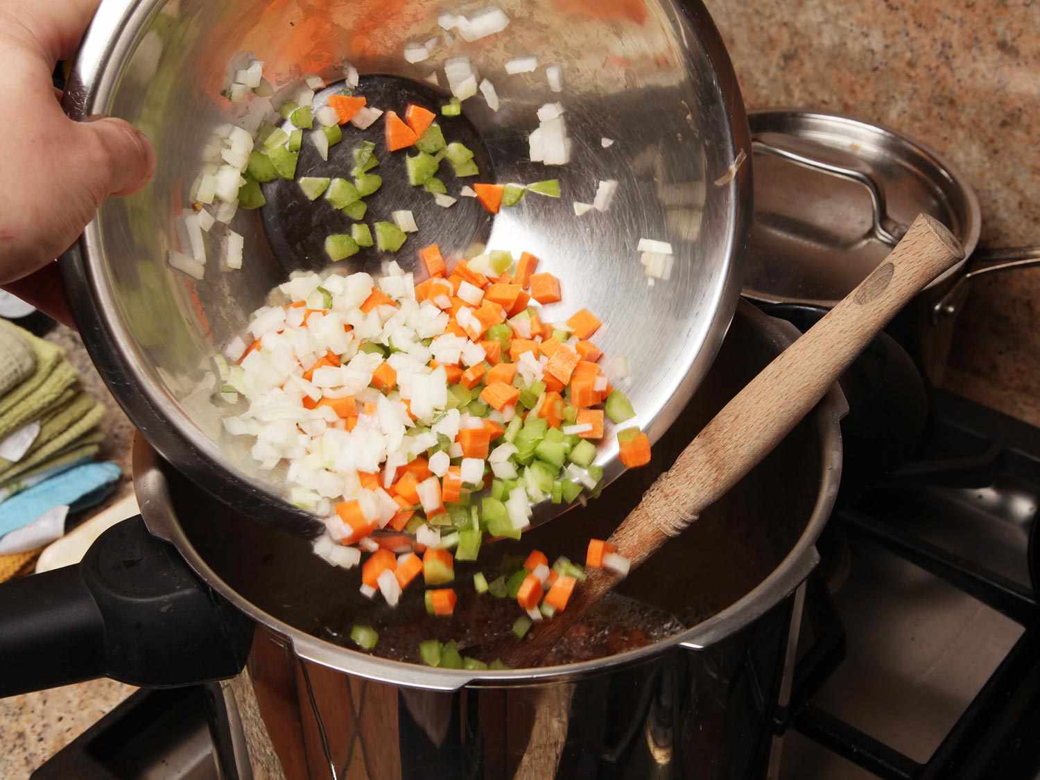 将一碗切碎的洋葱、胡萝卜和芹菜放入高压锅中。gydF4y2Ba