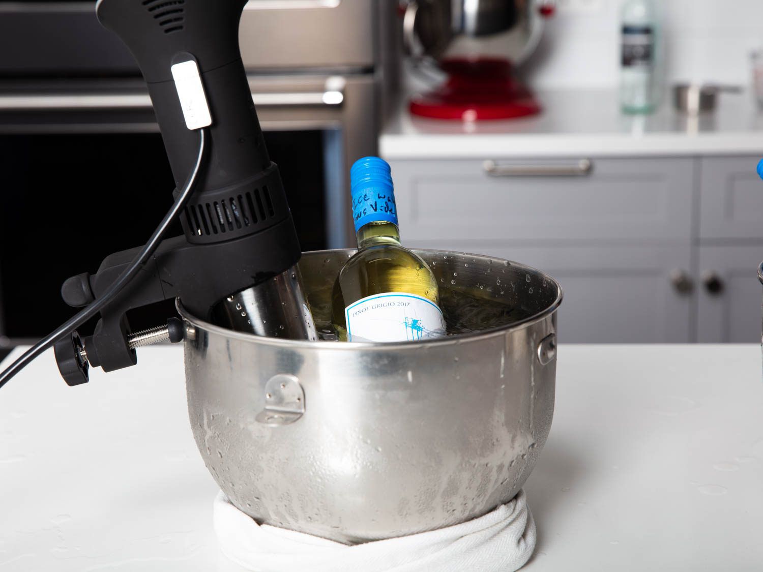 装有浸没式循环器的立式搅拌碗中的一瓶白葡萄酒