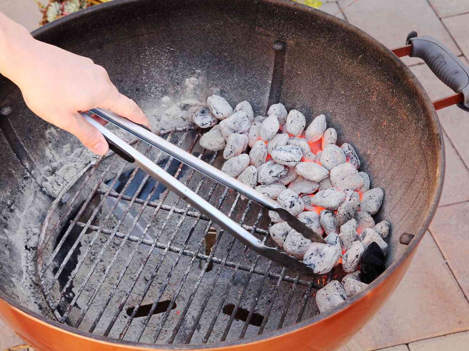 将点燃的煤炭放在烧烤格栅的一侧，用于两个区域的火灾