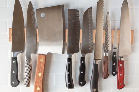 各种不同的刀挂在一个磁性木刀座