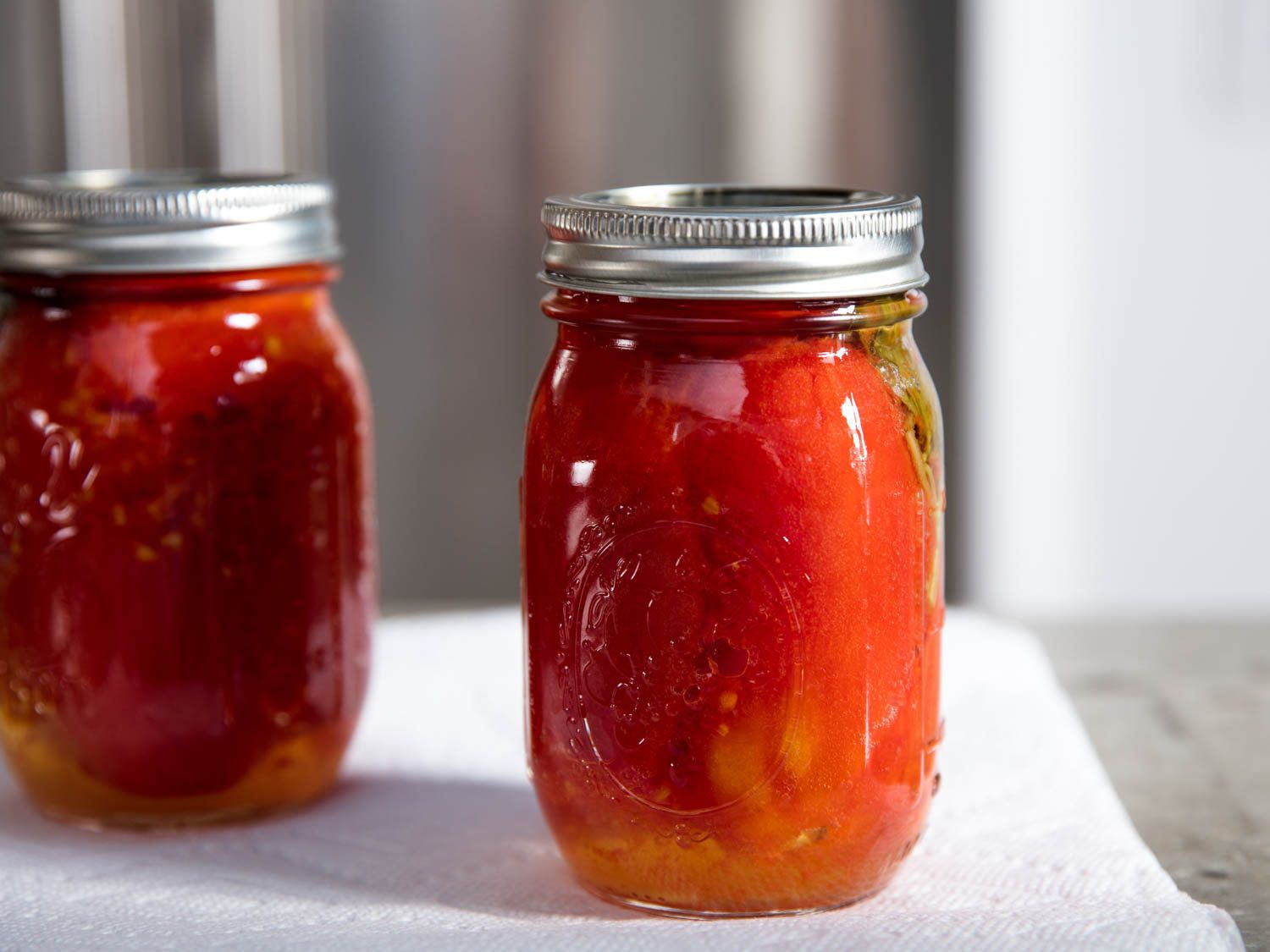 两个密封的玻璃瓶，里面装满了腌制的西红柿。