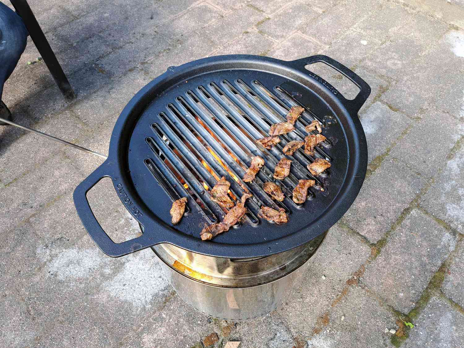 在单独的炉子上用烤架和轮毂烹饪切成薄片的腌好的肉