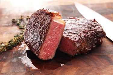 Medium rare steak halved on a cutting board