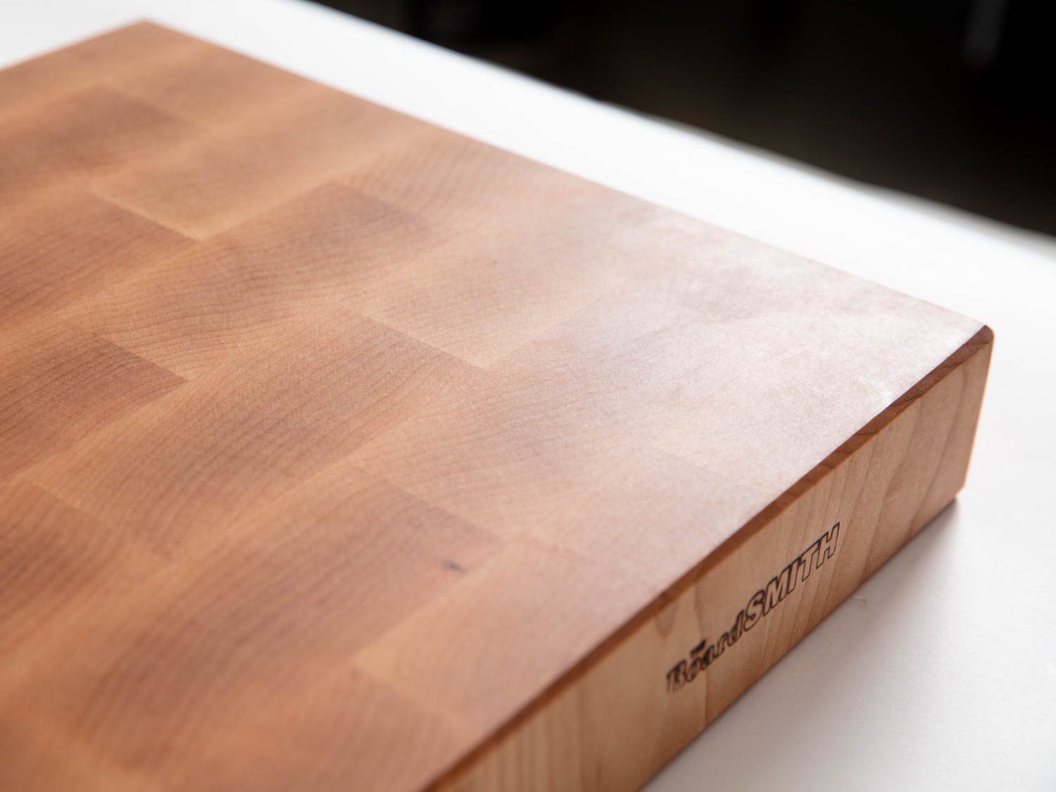 在木板史密斯的端纹枫砧板上的精细完成，显示光反射在平滑完成的表面上
