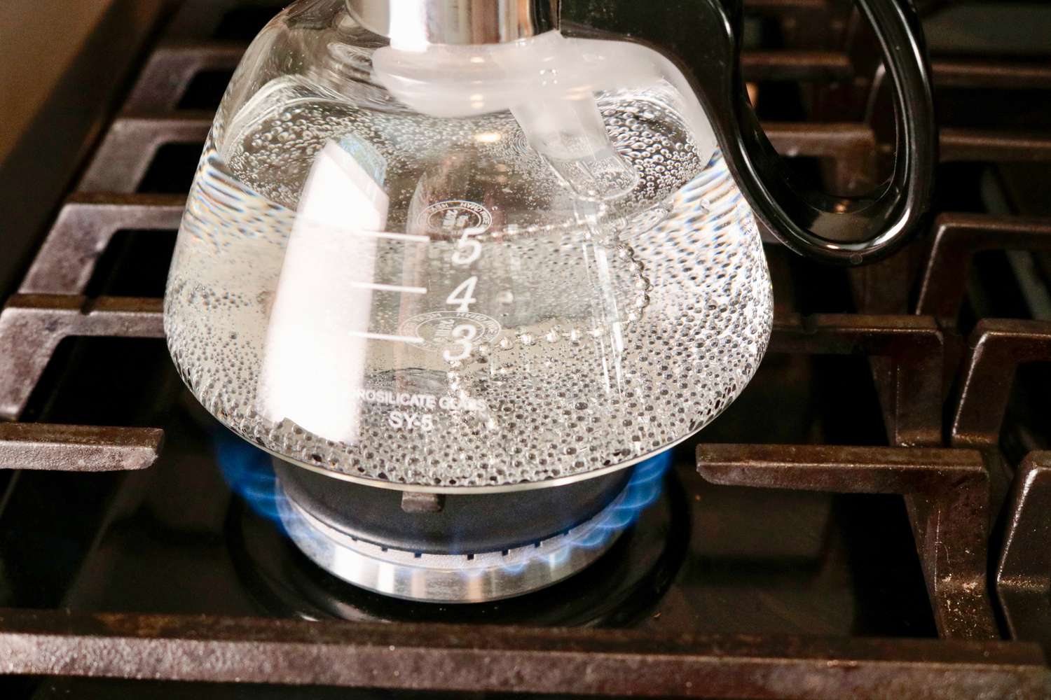 一个近距离的水在一个玻璃咖啡酿造室沸腾