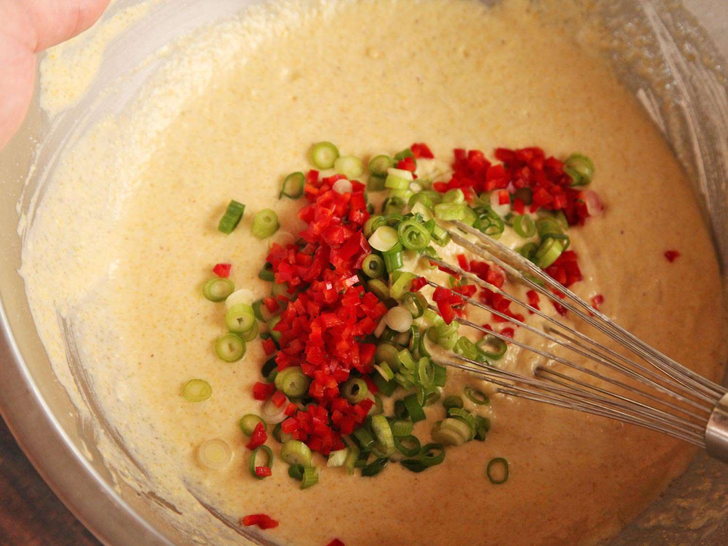 红色jalapeño和葱花折入玉米面包面糊中。
