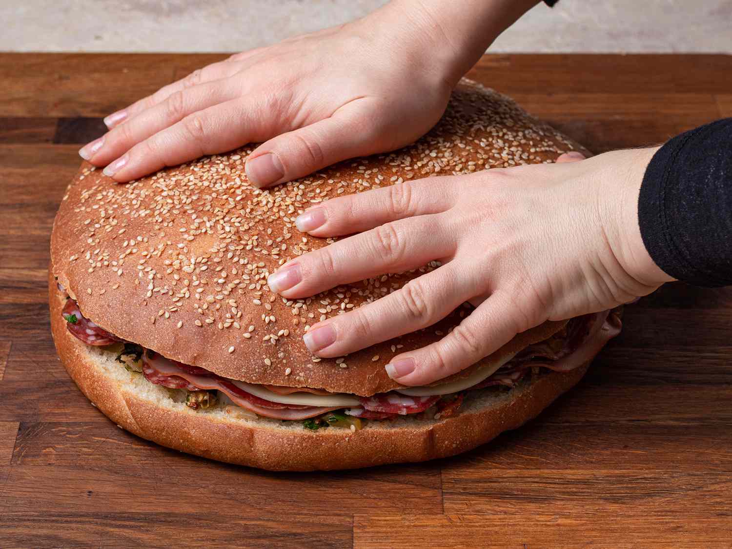 马夫莱塔面包上面有两只手，有助于显示它非常大。