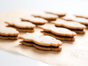 两行fudge-filled owl-shaped脆饼三明治饼干在羊皮纸上。