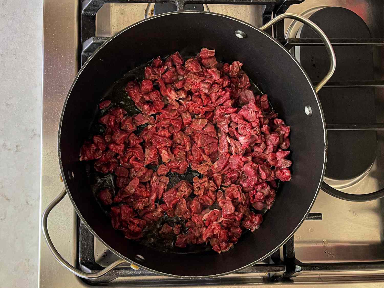 在一个大煎锅里用酥油煮牛肉和香料。