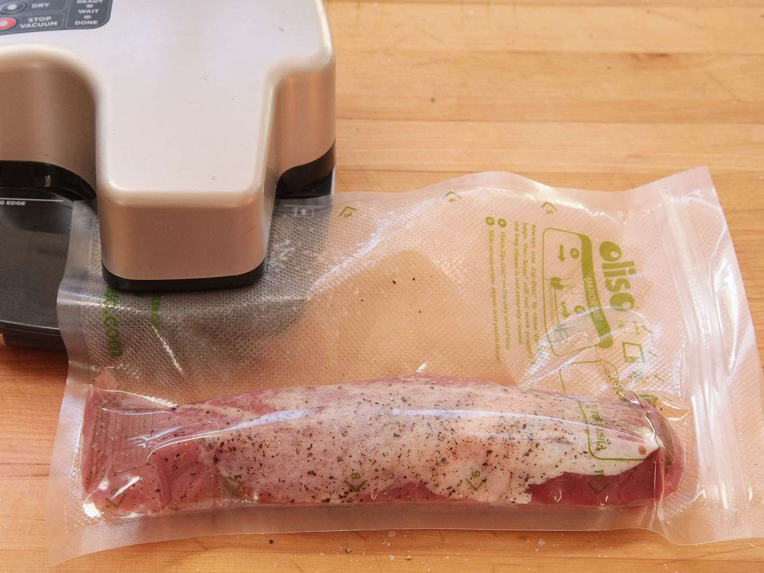 Sealing a sous vide bag with seasoned pork loin in it before cooking sous vide.