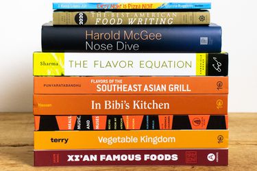 a stack of cookbooks on a wooden tabletop
