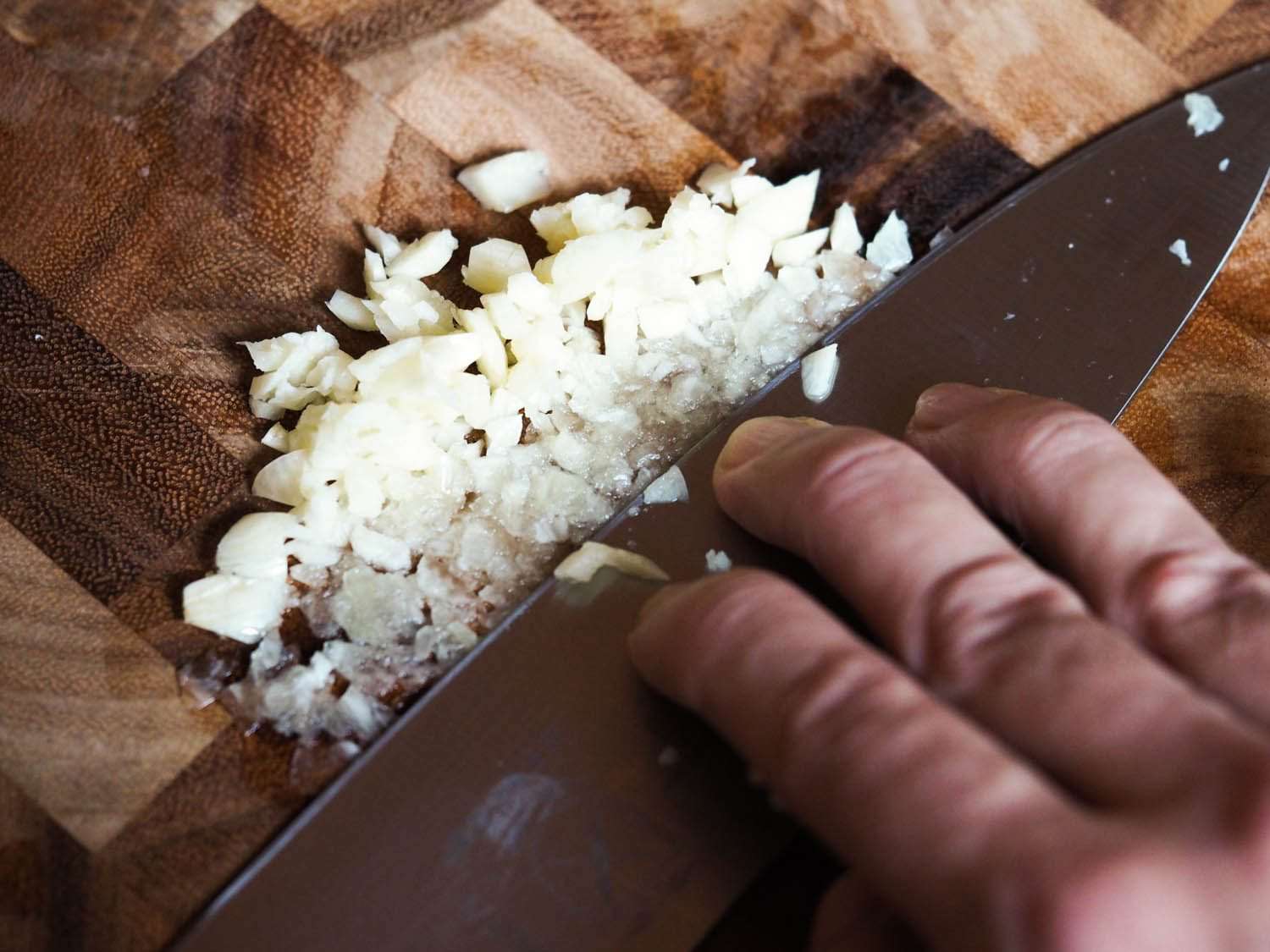 用刀尖压碎大蒜。