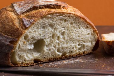 一条简单的硬皮白面包，旁边还有一片面包。